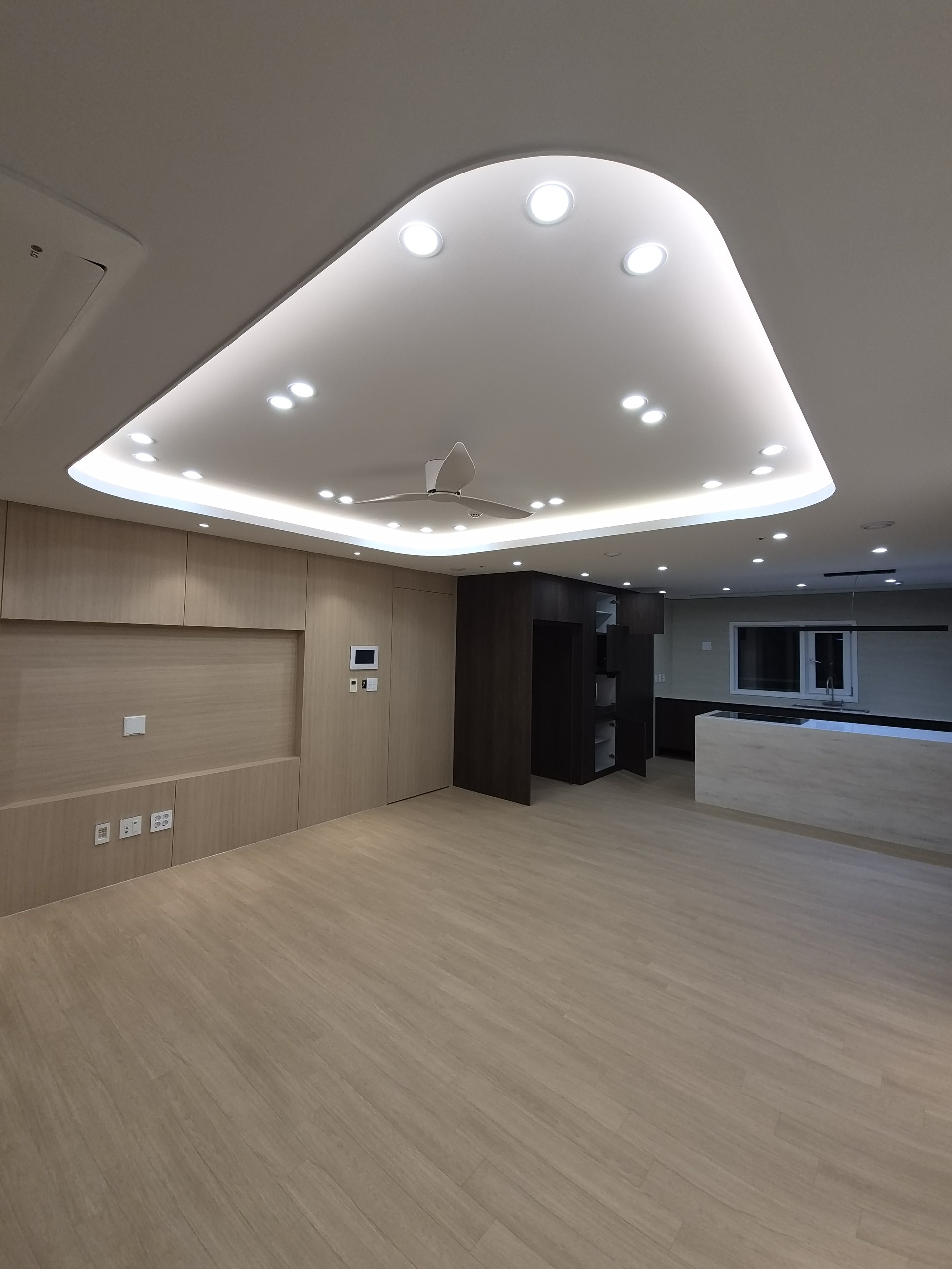 거실에서 주방을 바라본 전경. 밝고 짙은 우드톤이 대비됩니다.